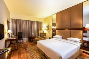 a hotel room with a large bed and a desk at Courtyard by Marriott Ahmedabad in Ahmedabad