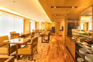 a restaurant with tables and chairs and a kitchen at Courtyard by Marriott Ahmedabad in Ahmedabad