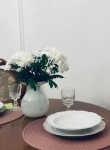 a table with a plate and a vase with white flowers at LittleParis in Cluj-Napoca