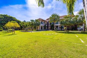 une grande cour en face d'une maison avec des palmiers dans l'établissement Luxurious 6 Bedroom Mansion Close To Beach CAS, à Cha Am