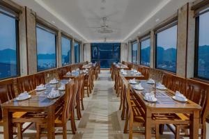 une rangée de tables dans une pièce avec fenêtres dans l'établissement Aroma Cat Ba Sea View Hotel, à Cat Ba