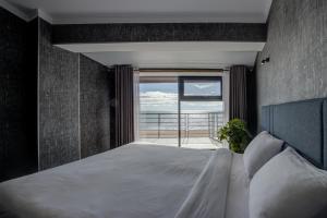 a bedroom with a bed with a view of the ocean at Vzmorie Resort Hotel in Bosteri