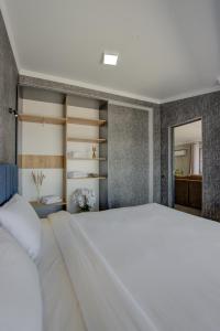 ボステリにあるVzmorie Resort Hotelのベッドルーム(大きな白いベッド1台、棚付)
