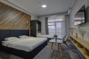a bedroom with two beds and a table in it at Vzmorie Resort Hotel in Bosteri