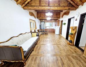 sala de estar con sofá y suelo de madera en Songjukheon Pension, en Damyang