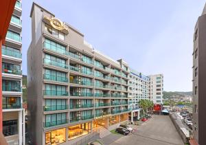 巴東海灘的住宿－Grace Patong Hotel，一座高大的建筑,旁边有一个标志