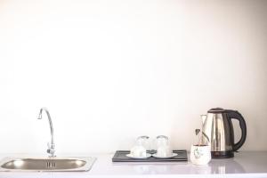 a kitchen counter with a sink and a tea kettle at TTR Midtown View Hotel in Da Lat