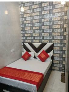 a bed with red pillows in a room at Punjabi Residency(niwas) in Amritsar