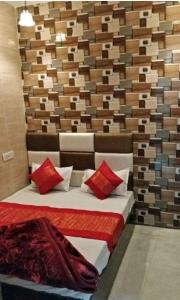 a bedroom with a bed with red pillows at Punjabi Residency(niwas) in Amritsar