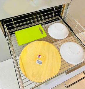 a metal rack with three white plates and a wooden plate at La Alba 1 BHK Serviced Apartment in Mumbai