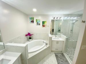a bathroom with a tub and a sink and a shower at Greenlinks at Lely Luxury Purple Orchid Fully Renovated Modern 1st floor 3bdr Golf Resort Villa in Naples