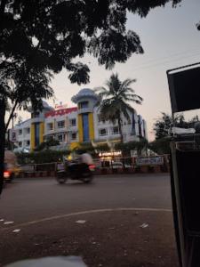 una persona que conduce una motocicleta por una calle de la ciudad en Hotel Embassy International,Latur, en Lātūr