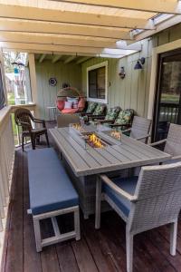 a wooden table and chairs on a deck at Swing into Summer at our Mountain Home with a River View in Blairsden