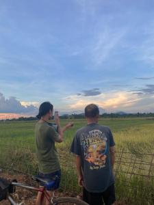 zwei Menschen, die auf einem Feld stehen und ein Foto machen in der Unterkunft Happy Homestay in Buon Ma Thuot