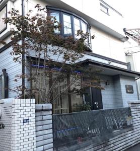una casa di mattoni bianchi con un albero di fronte di 冠京ホテル a Tokyo