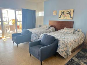 a bedroom with two beds and a chair at Casa Colibri - Private Beachfront Oasis in Cruz de Huanacaxtle +48 photos