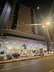 un grande edificio con macchine parcheggiate di fronte di Nawazi Towers Hotel a La Mecca