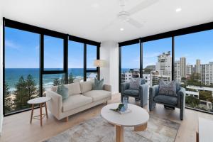 a living room with a couch and chairs and windows at Sandbar Burleigh in Gold Coast