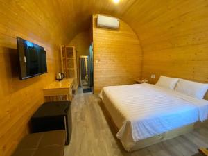 1 dormitorio con 1 cama en una habitación de madera en Khách Sạn Măng Đen Xanh en Kon Plong