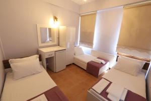 um pequeno quarto com 2 camas e um espelho em Cunda Pera Otel em Ayvalik