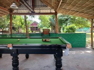 uma mesa de bilhar verde num quarto com toldo em Le Soleil em Kep