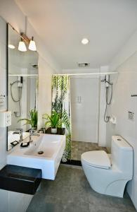 La salle de bains blanche est pourvue de toilettes et d'un lavabo. dans l'établissement PapaCrab Boutique Guesthouse, à Kamala Beach
