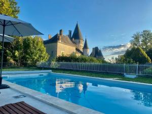 a swimming pool in front of a castle at Château des Feugerets in Bellême