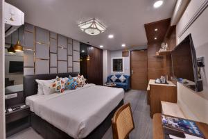 a bedroom with a bed and a desk and a television at The Fern Habitat, Jaipur in Jaipur