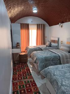 Wanas Kato Guest House في Shellal: غرفة نوم بأربعة أسرة في غرفة