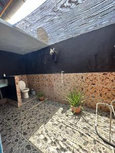 a bathroom with a toilet and some plants in it at Melbao Homestay in Gili Air