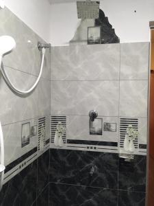 baño con ducha con gatos en la pared en Sky Family Villa Ahangama en Ahangama