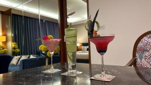 drie cocktails op een tafel in een kamer bij The Conway in Meerut