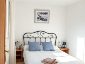a bedroom with a white bed with blue pillows at Can Freixa, fantástica villa con piscina in Sóller