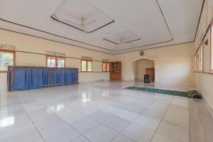 um quarto grande com um piso branco e uma cortina azul em RedDoorz Syariah at Bumi Eyang Enin Homestay Tasikmalaya em Tasikmalaya
