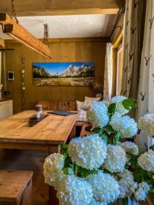 a room with a table and a vase of blue flowers at Chalet Wildalpen (in Ruhelage & mit Wellness) in Wildalpen