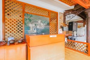a kitchen with a wall with a painting on it at RedDoorz Syariah at Bumi Eyang Enin Homestay Tasikmalaya in Tasikmalaya