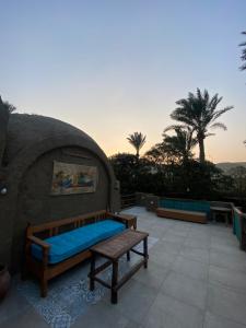 un patio con sofá, banco y palmeras en Nassimah en Giza