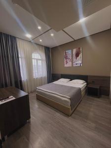 a bedroom with a large bed and a table at Bien hotel in Yerevan