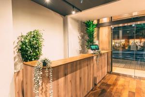 um lobby com um balcão com vasos de plantas em Tokyo Guesthouse HIVE em Tóquio