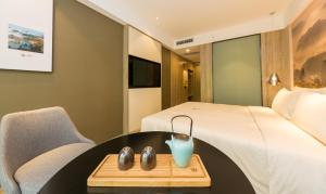 a hotel room with a bed and a table and a chair at Atour Hotel Chongqing Hongyadong Riverview in Chongqing