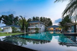 uma casa com piscina em frente a uma casa em Baag E Fursat - Luxurious 10BR Villa with infinity swimming pool em Kūrāli