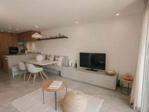 ein Wohnzimmer mit Fernseher und Tisch und Stühlen in der Unterkunft Casa Mirador, vacaciones Puerto de Sóller in Port de Sóller