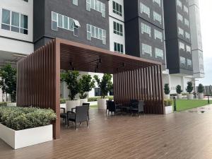 a patio with tables and chairs in front of a building at Melaka AmberCove 2R2B 5 pax 1 Parking Melaka Straits View Pool in Melaka