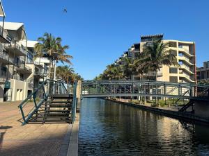 a bridge over a river with palm trees and buildings at DNA Dream Home in Durban