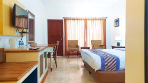 a hotel room with a bed and a desk and a table at Puri Lovina in Lovina