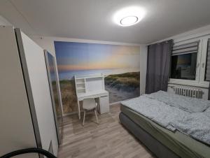 a bedroom with a bed and a desk in it at NB Vogelviertel zwei Zimmer Wohnung in Neubrandenburg