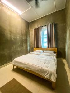 um quarto com uma cama num quarto em TERATAK ZAINAB GUEST HOUSE KOTA BHARU em Kota Bharu