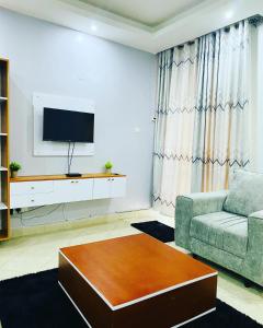 salon z kanapą i telewizorem z płaskim ekranem w obiekcie Adea Apartments Munyonyo w mieście Kampala