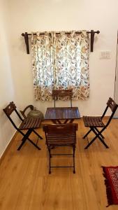 Habitación con 2 sillas, mesa y ventana en Jawai Legacy Shambhala, en Sheoganj