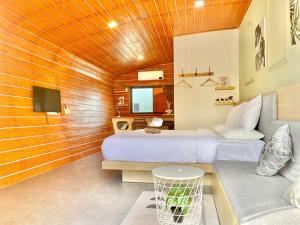 a room with two beds and a couch and a tv at สต็อกโฮม เขาใหญ่ (StockHome Khao Yai) in Khanong Phra